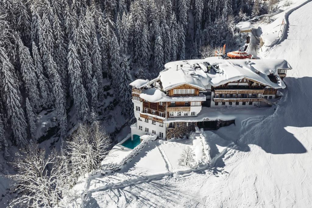 budynek pokryty śniegiem na szczycie góry w obiekcie Mooser Hotel w mieście Sankt Anton am Arlberg