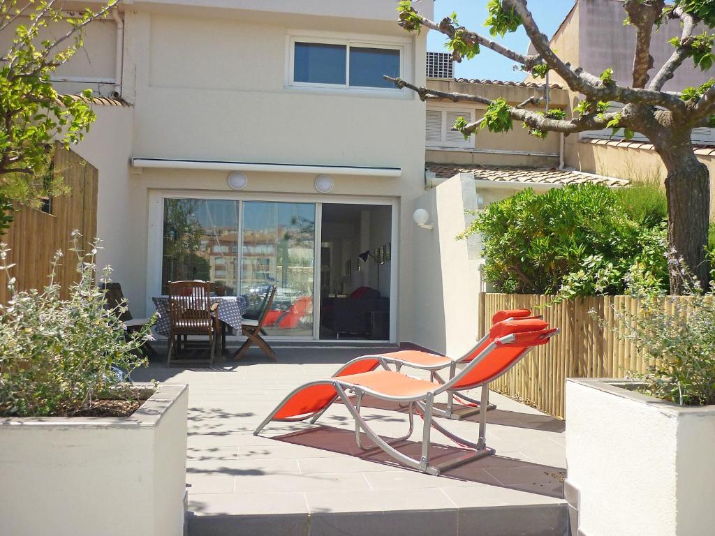 a pair of chairs sitting on a patio in front of a house at Holiday Home Les Marines du Cap.4 in Cap d'Agde