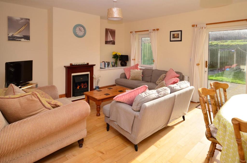 a living room with two couches and a fireplace at Cottage 323 - Cleggan in Cleggan