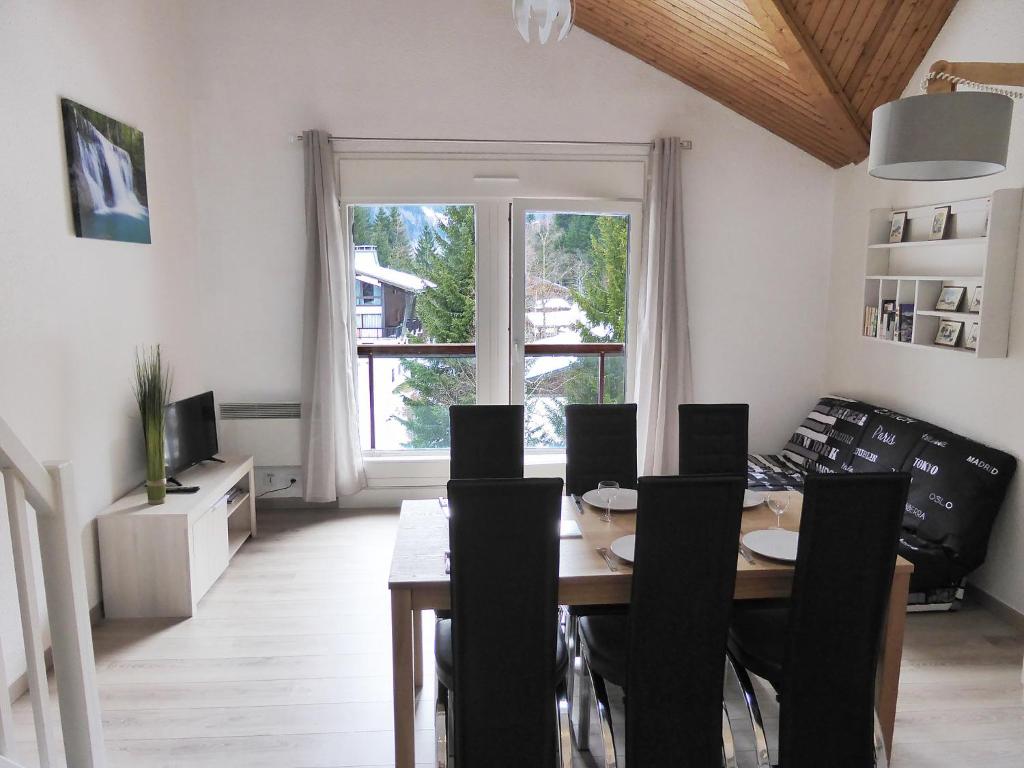une salle à manger avec une table et des chaises et une fenêtre dans l'établissement Apartment La Borgia A- B- C-10 by Interhome, aux Contamines-Montjoie