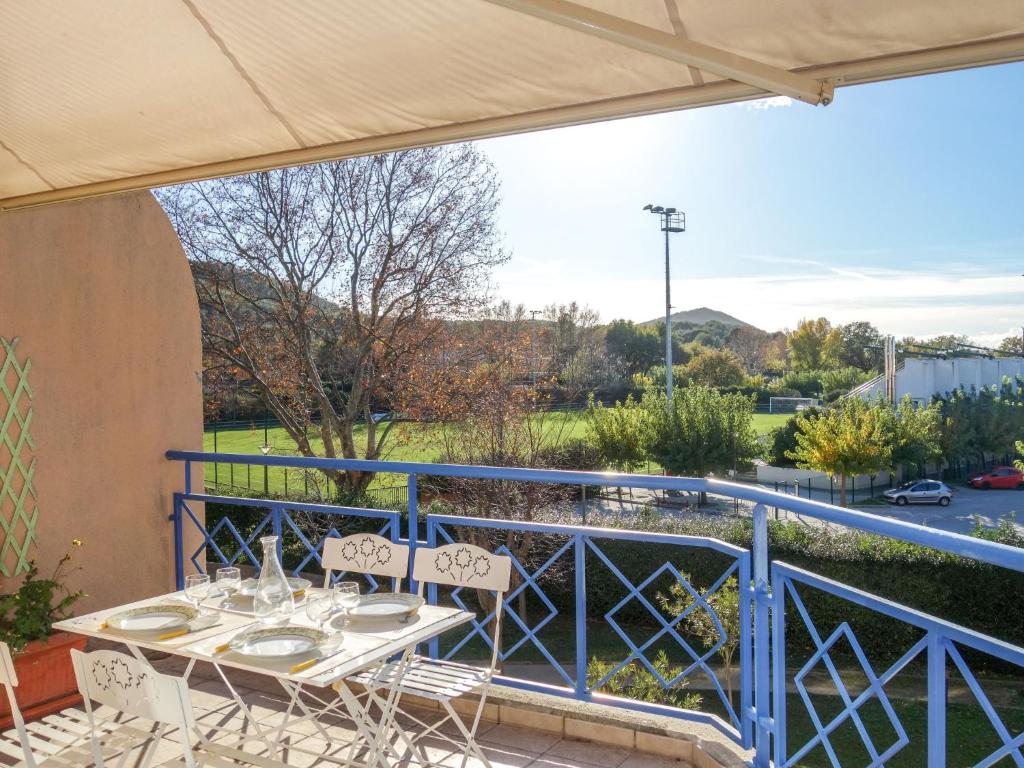 Un patio con una mesa y sillas en un balcón. en Apartment Le Stadium-5 by Interhome, en Saint-Cyr-sur-Mer