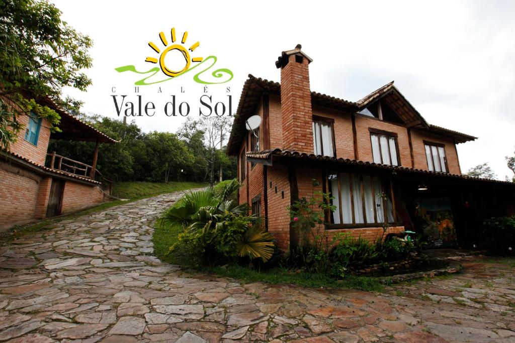 a brick house with a sign that says vale do sul at Pousada Chalés Vale do Sol in Conceição da Ibitipoca