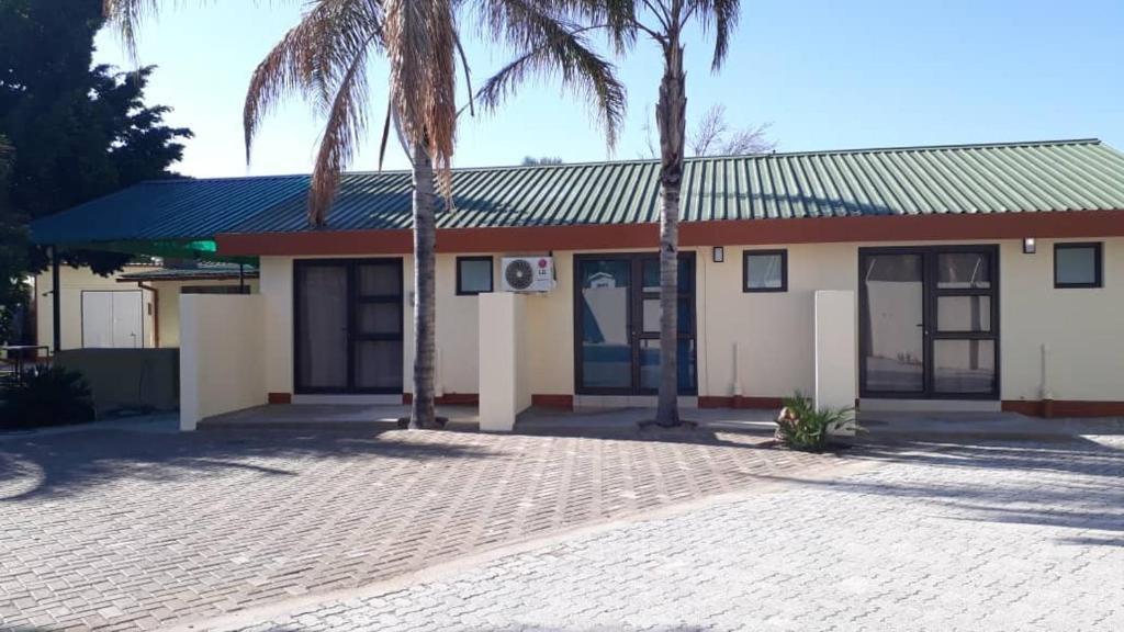 a building with palm trees in front of it at RY Courtyard in Oshakati