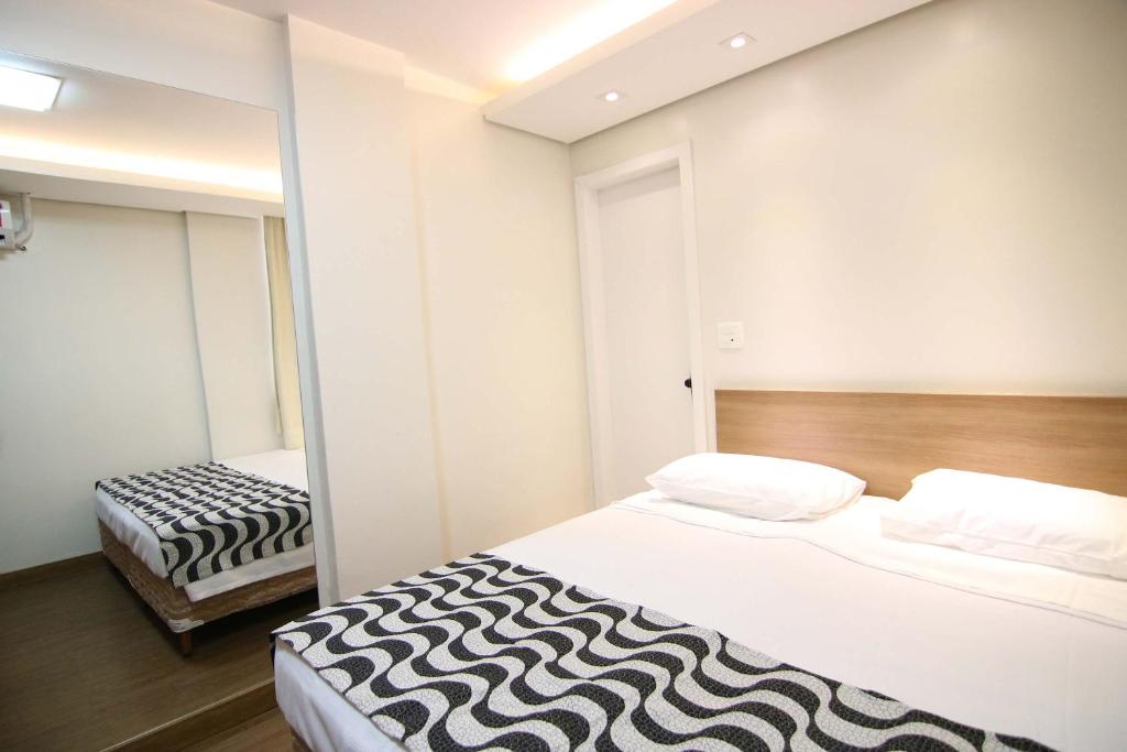 a room with a zebra print bed and a mirror at Samba Belo Horizonte Centro in Belo Horizonte