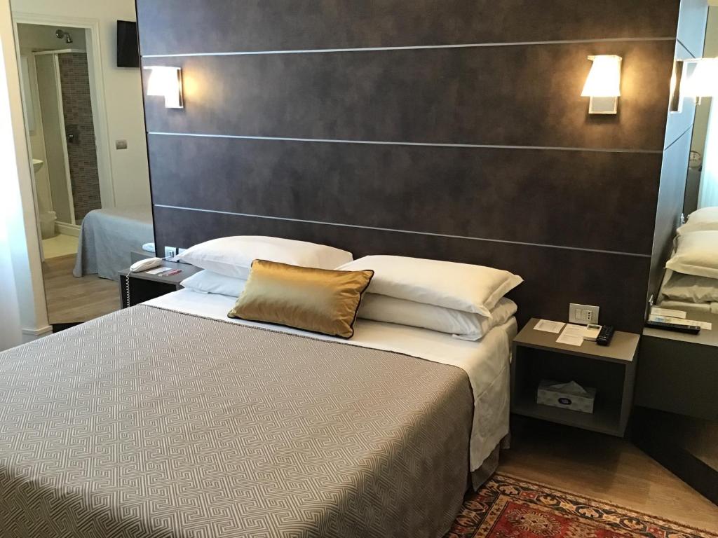 a hotel room with a bed with a large headboard at Hotel La Nuova Rotaia in Gallarate
