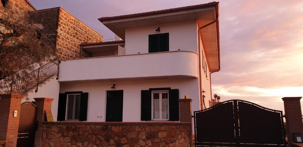 una casa blanca con persianas negras y una valla en B&B Il Falco e l'Ulivo, en Rocca Massima