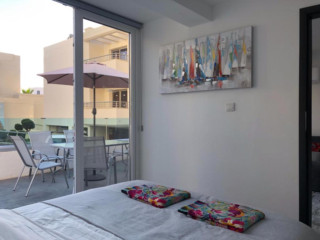 a bedroom with a bed and a view of a patio at Ayia Napa GO SEA apt. in Ayia Napa