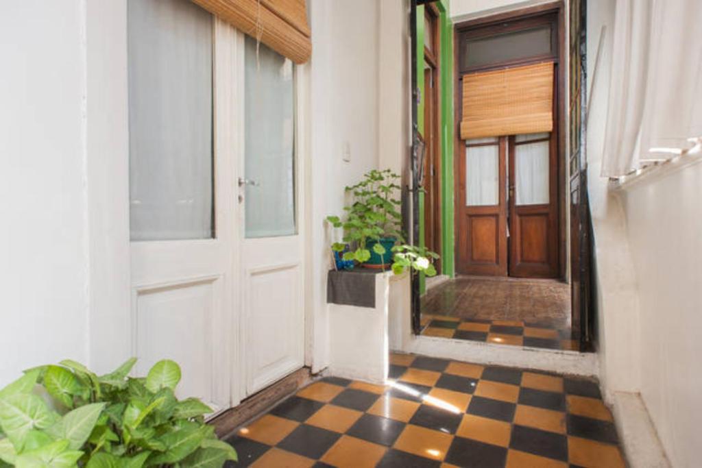 a hallway with a checkered floor in front of a door at La Boca B&B in Buenos Aires