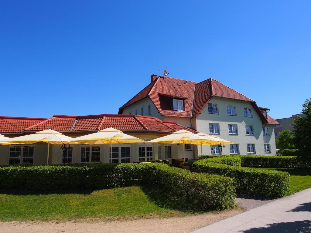 a large building with umbrellas in front of it at Hotel Haus am See in Olbersdorf