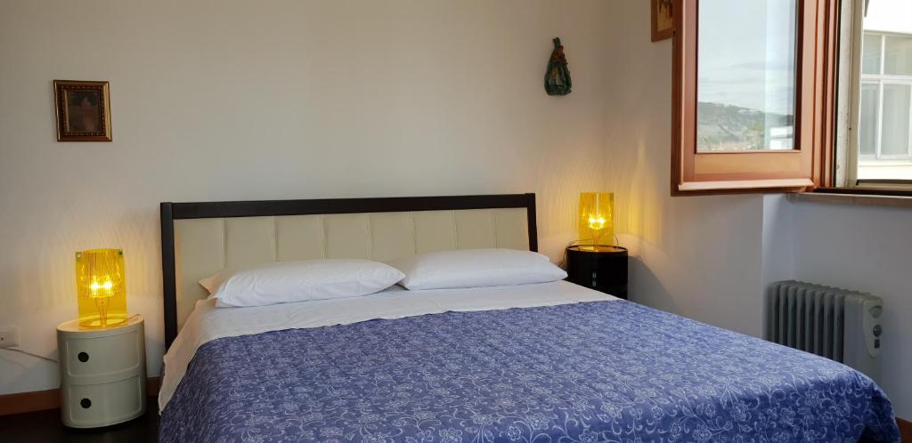 een slaapkamer met een bed met een blauw dekbed en 2 lampen bij Casa Vacanze LELUPE in Sant'Agnello