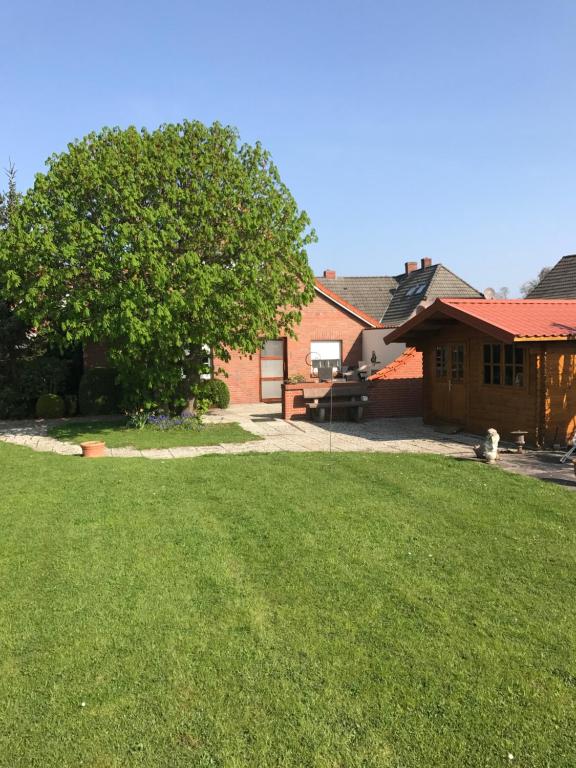 um quintal com uma casa e uma árvore em Haus Inge Ysker em Greetsiel