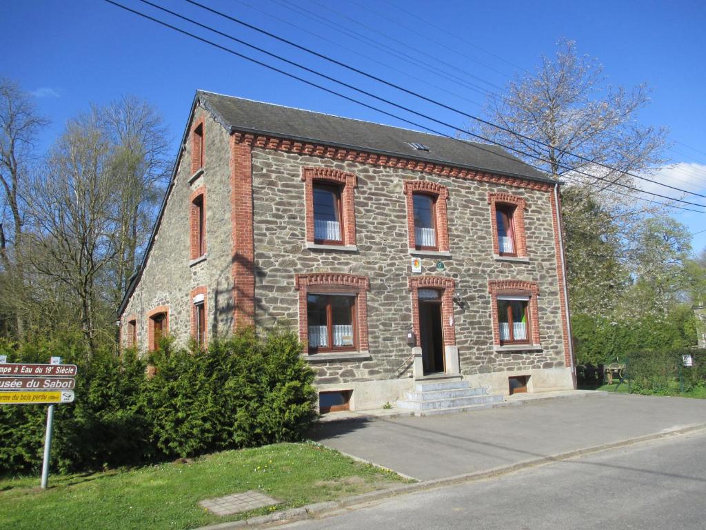 an old brick building on the side of a street at Chambres d'hôtes des Ardennes in Porcheresse