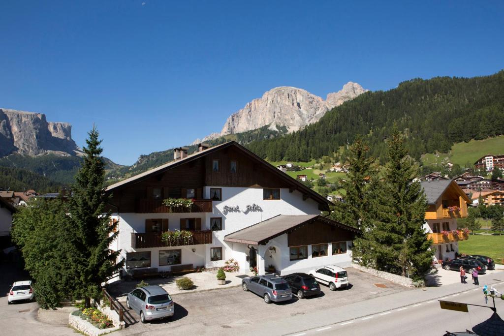 een hotel in de bergen met auto's geparkeerd op een parkeerplaats bij B&B Residence Adria in Corvara in Badia