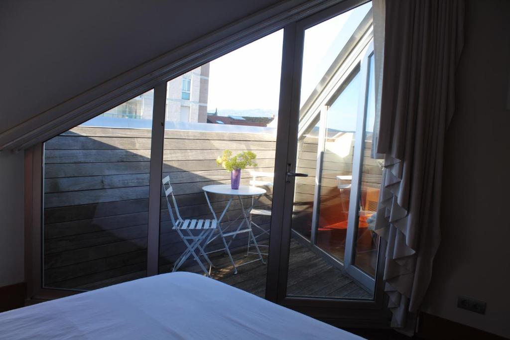 維戈的住宿－A casa Rosa- Ático en el centro de Vigo，一间卧室,享有带桌子的阳台的景色