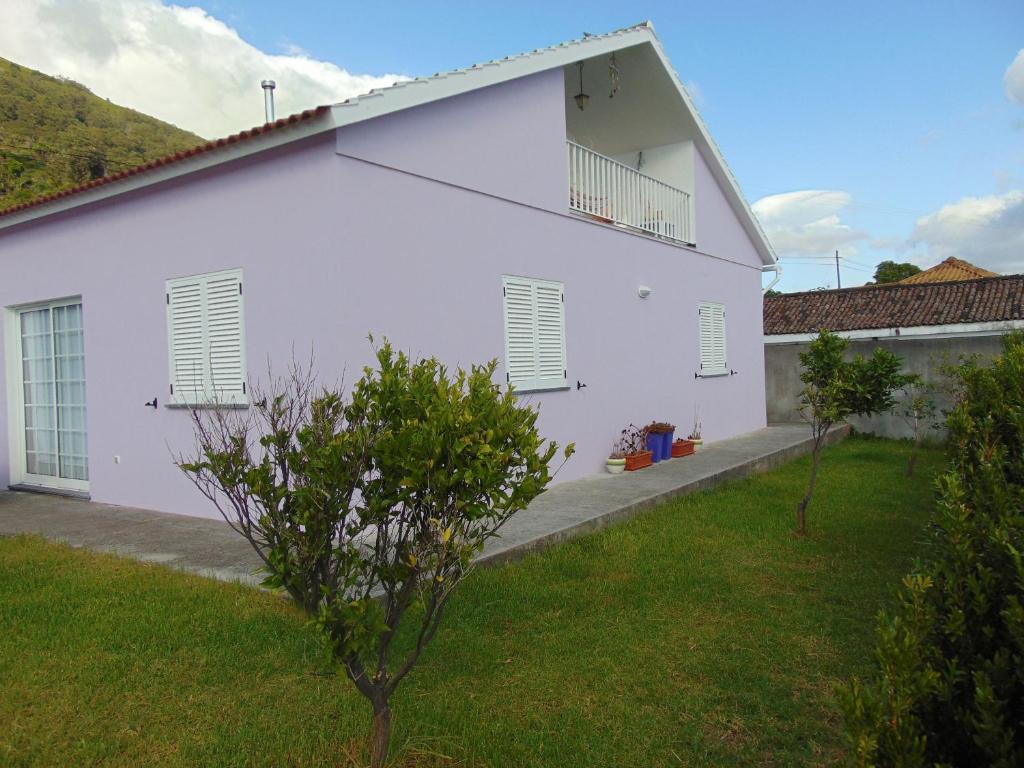 una casa bianca con un albero in cortile di Casa do Carroça a Terreiros