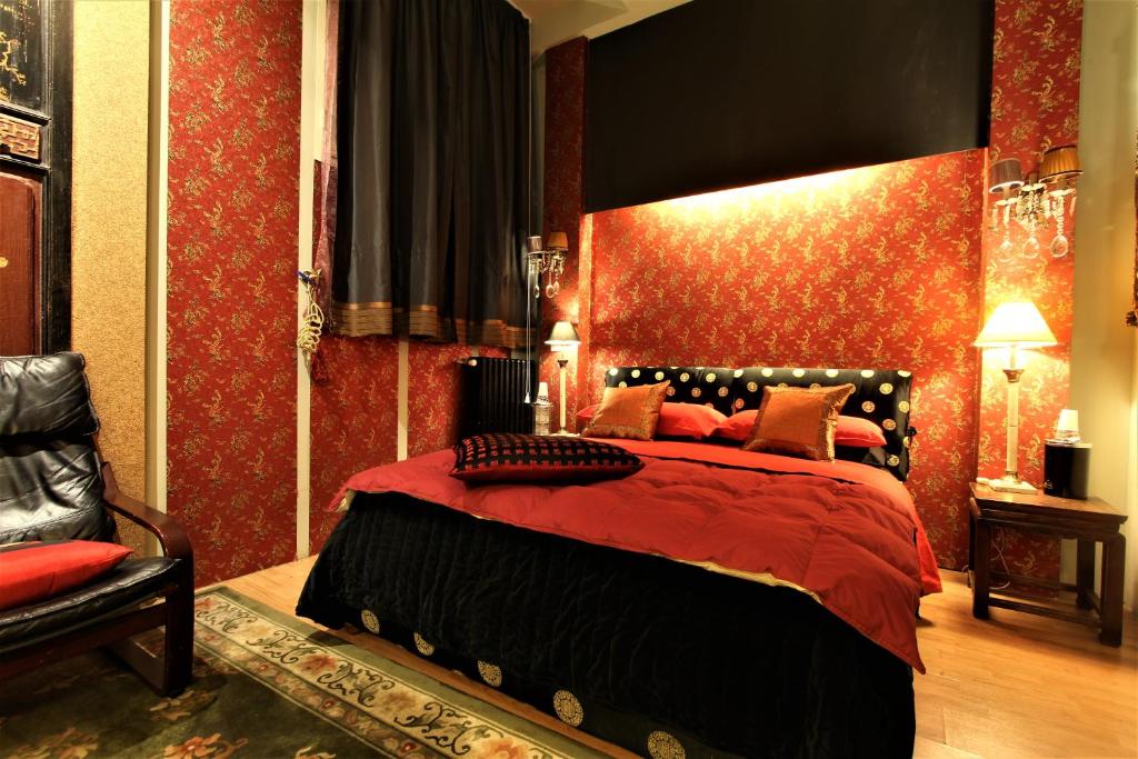 a bedroom with a bed with a red wall at LU Suites in Turin