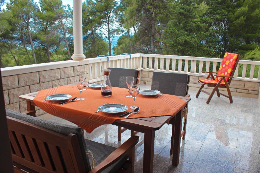 einen Holztisch mit Weingläsern auf einer Terrasse in der Unterkunft Apartment Pez - with large terrace in Mirce