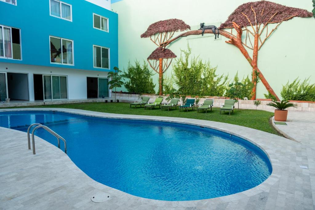 a swimming pool in front of a building at Hotel Playa Encantada in Playa del Carmen