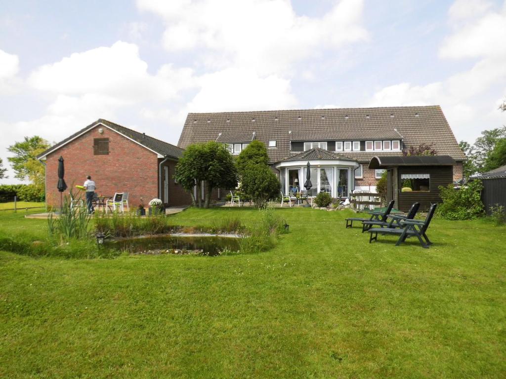 a house with a picnic table in the yard at Hotel garni Morsum in Nordstrand