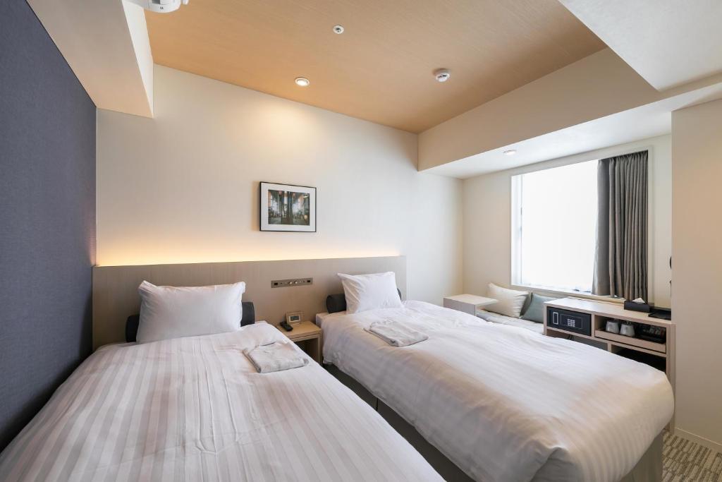 Postel nebo postele na pokoji v ubytování Ginza Capital Hotel Moegi