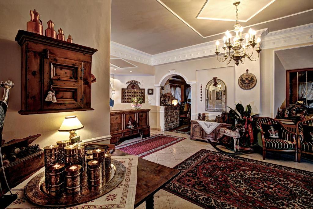 a large living room with a table and a couch at Hotel Regina in San Martino di Castrozza