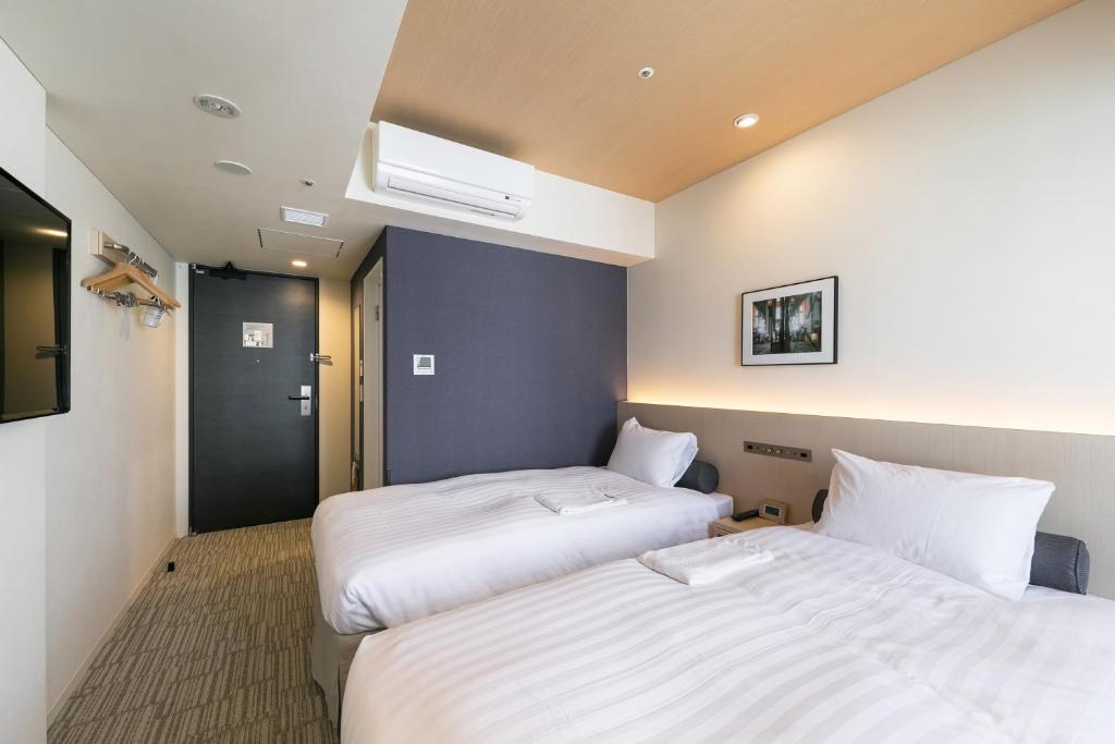 Postel nebo postele na pokoji v ubytování Ginza Capital Hotel Moegi