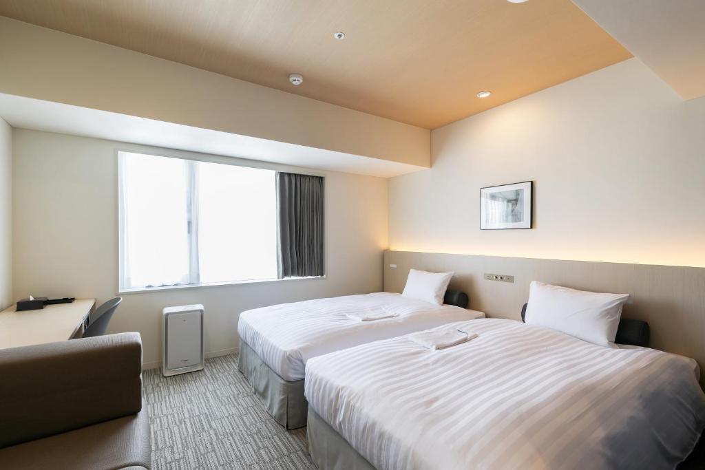 Postel nebo postele na pokoji v ubytování Ginza Capital Hotel Moegi