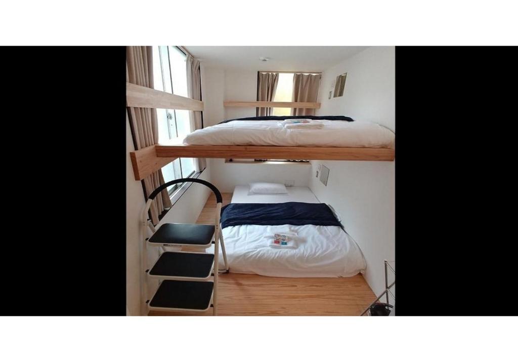 a small room with two bunk beds and a staircase at Nagoya Hostel The Three Smiles / Vacation STAY 13457 in Nagoya