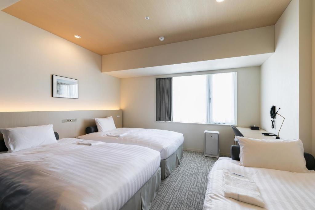 Postel nebo postele na pokoji v ubytování Ginza Capital Hotel Moegi
