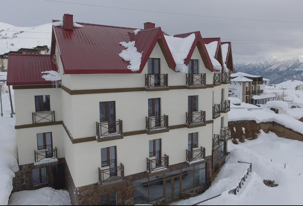a building with snow on the side of it at Hotel Ereto in Gudauri