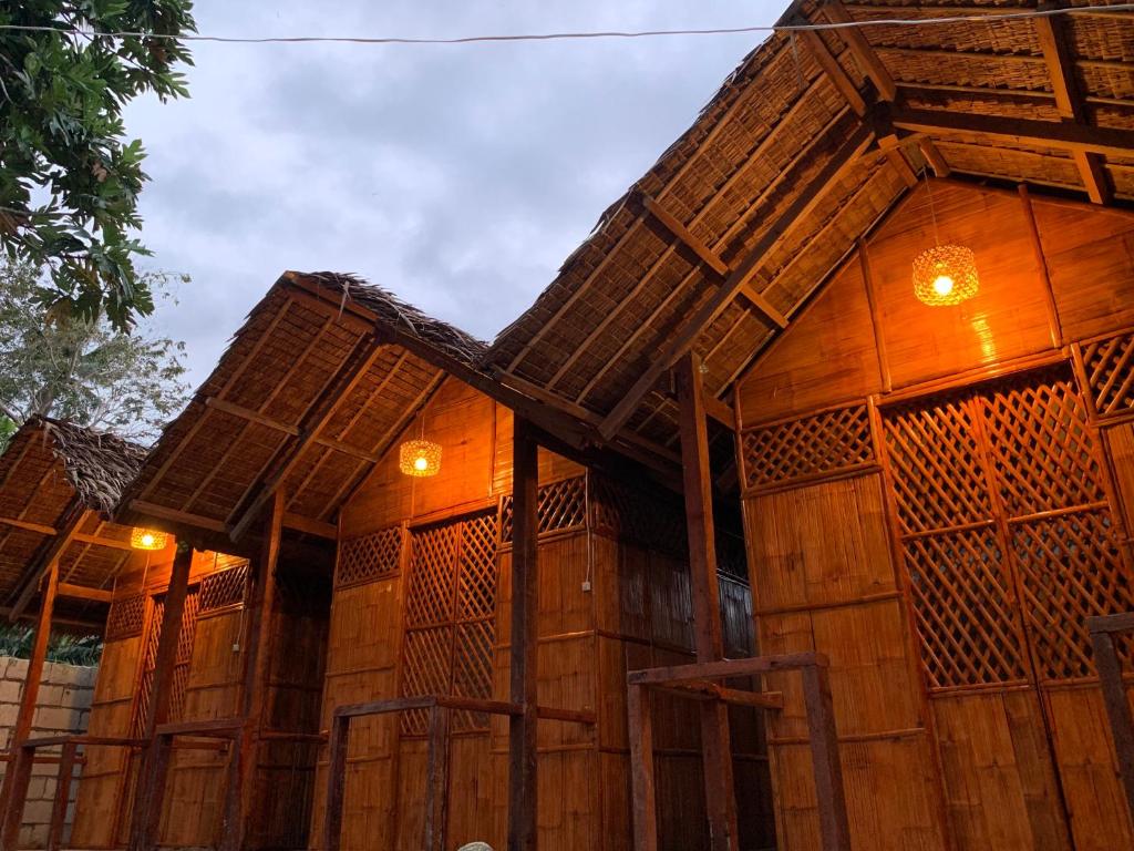 un edificio de madera con luces laterales en Suba Beach Nipa Huts en Daanbantayan