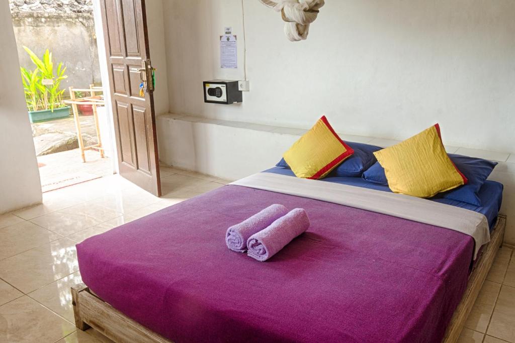 a bedroom with a large bed with two towels on it at Kris Kos in Canggu