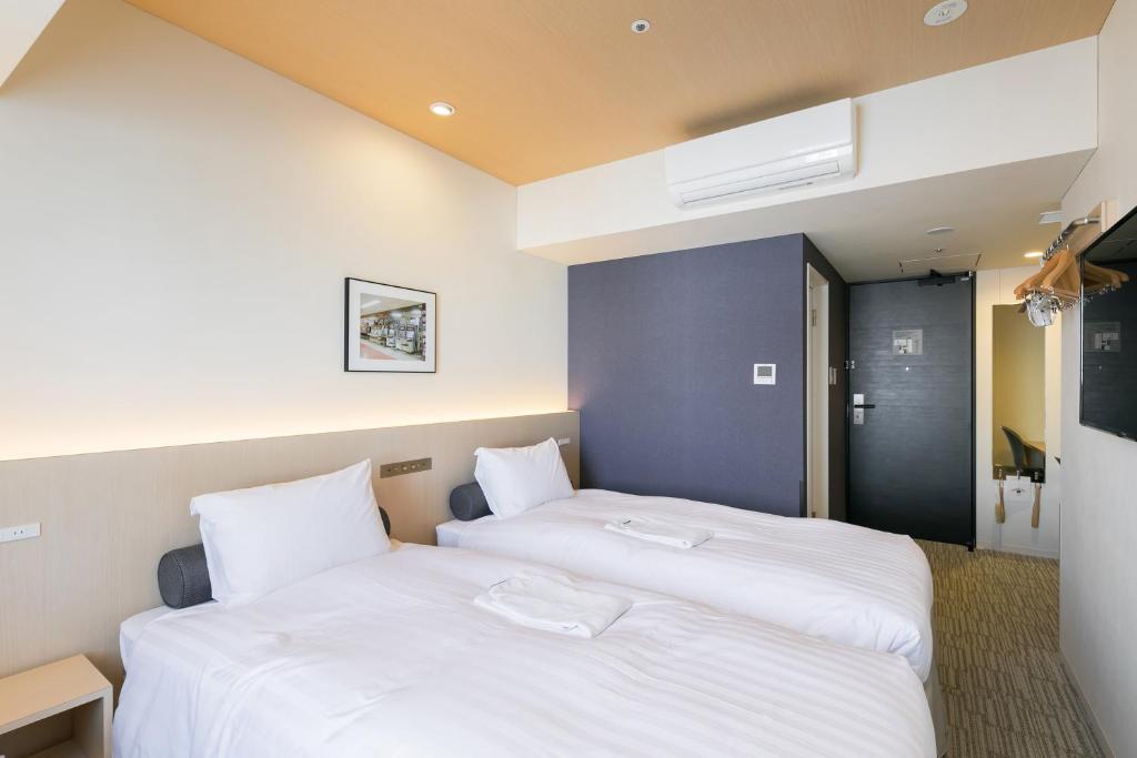Postel nebo postele na pokoji v ubytování Ginza Capital Hotel Moegi
