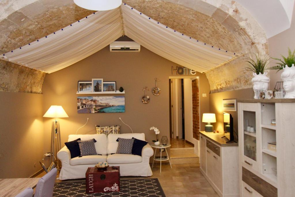 a living room with a white couch and a ceiling at Casa Gargallo 28 in Siracusa