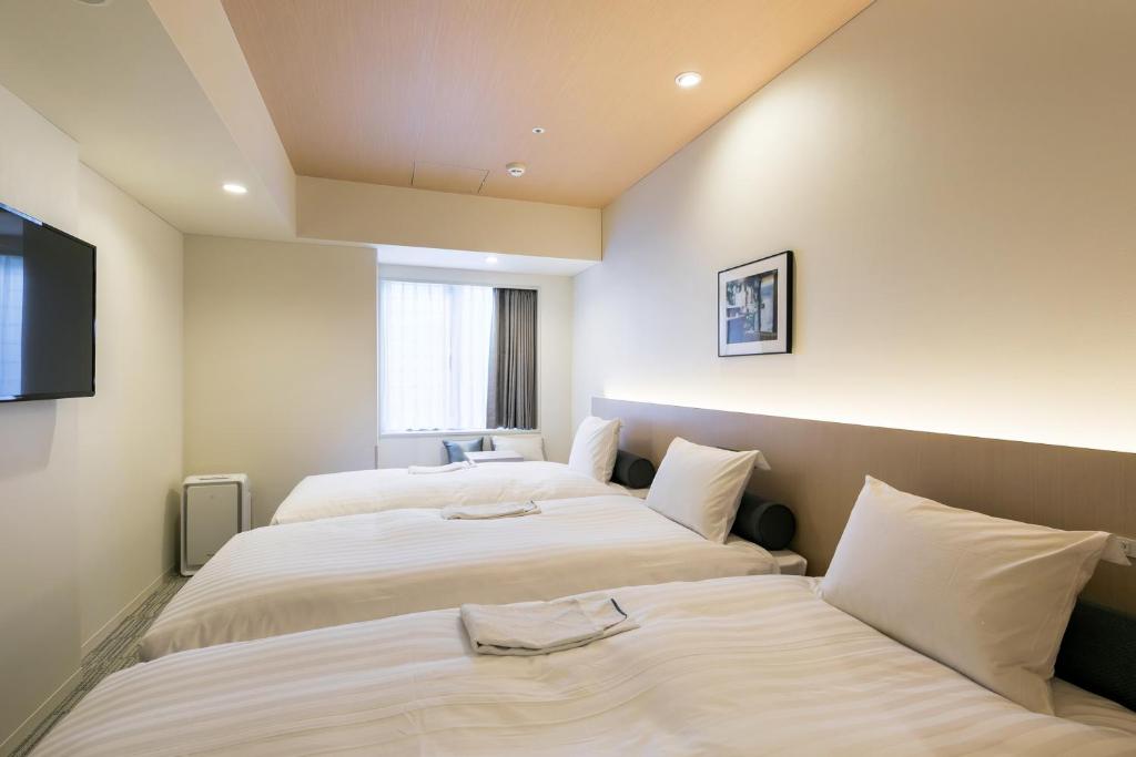 Postel nebo postele na pokoji v ubytování Ginza Capital Hotel Moegi
