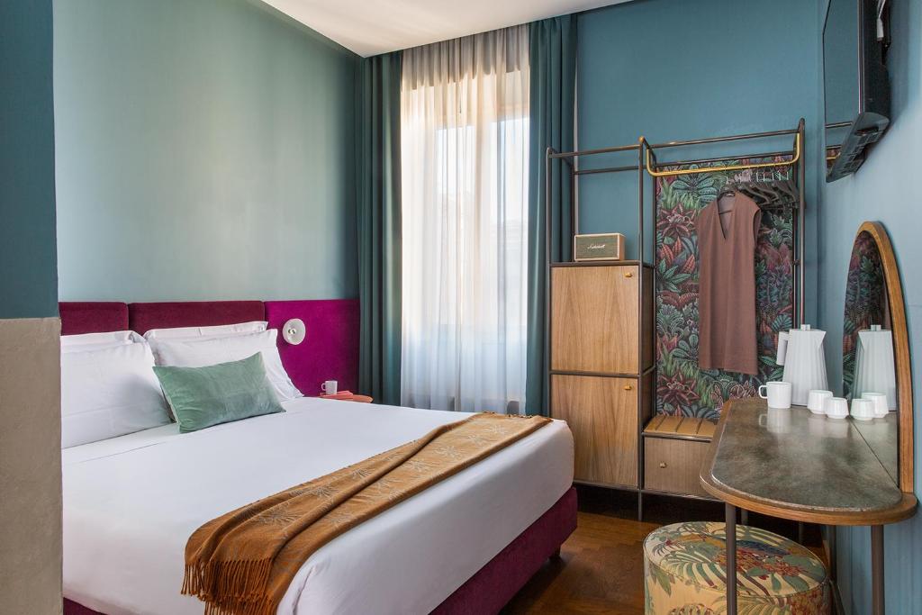 a bedroom with a large bed and a window at Condominio Monti Boutique Hotel in Rome