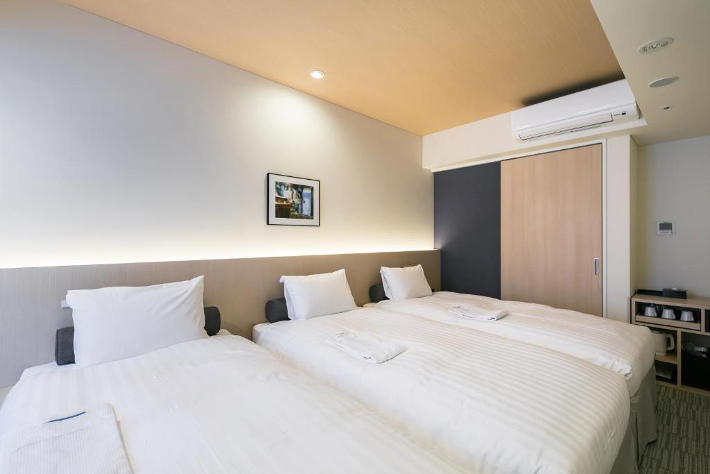 Postel nebo postele na pokoji v ubytování Ginza Capital Hotel Moegi