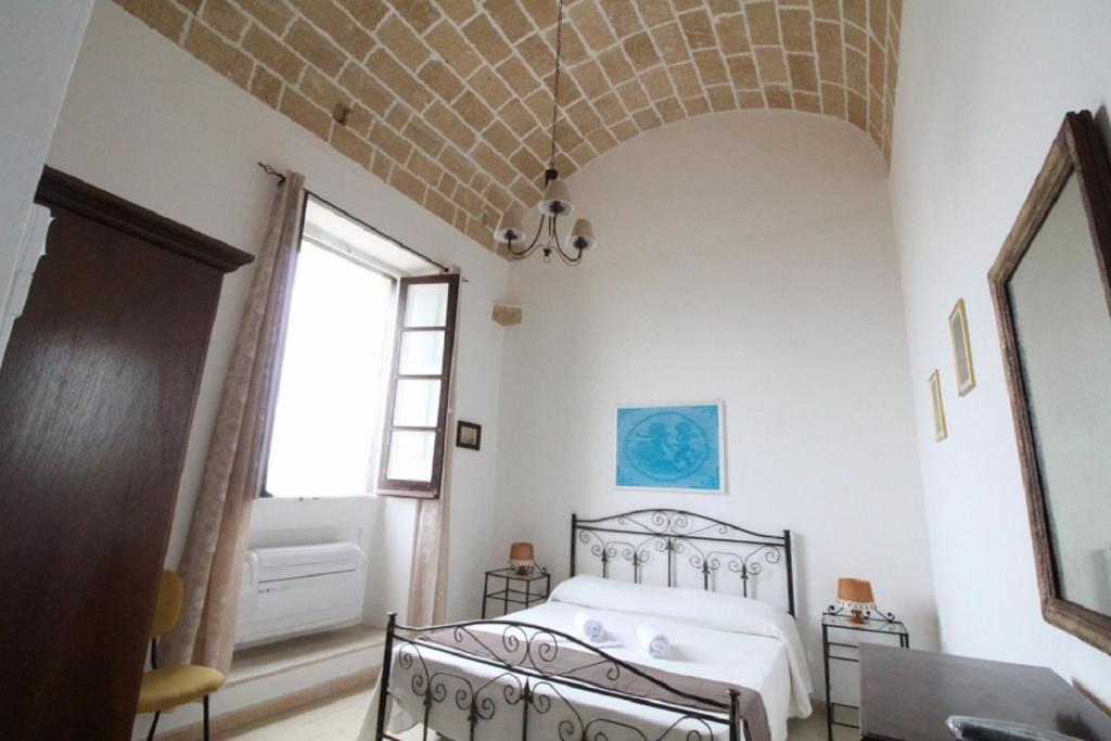 una camera con letto e soffitto in mattoni di Camera vista mare Holidayz a Gallipoli