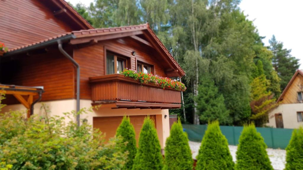 a house with a balcony with flowers on it at Stará Lesná ADEX in Stará Lesná