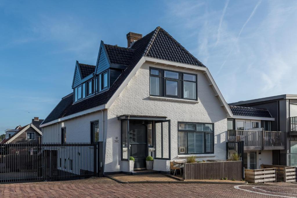 una casa blanca con techo negro en SummerTime Bergen aan Zee, en Bergen aan Zee