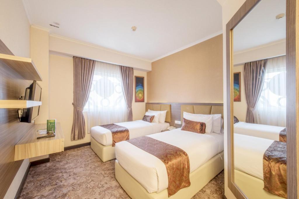 Postel nebo postele na pokoji v ubytování Lorin Syariah Solo Hotel