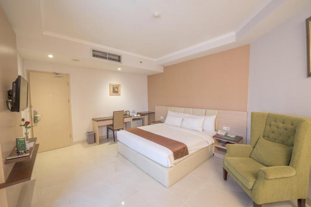 Postel nebo postele na pokoji v ubytování Lorin Syariah Solo Hotel