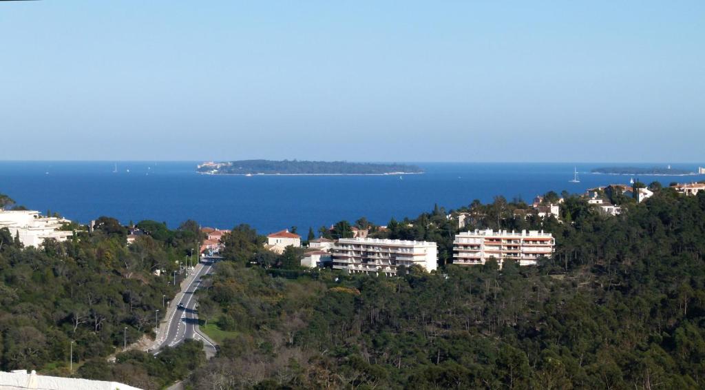 une ville sur une colline avec l'océan en arrière-plan dans l'établissement Le JASMIN, à Mandelieu-la-Napoule