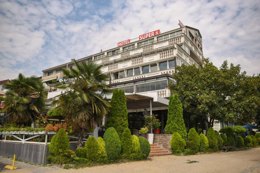 a white building with a sign on top of it at Hotel Super 8 in Skopje