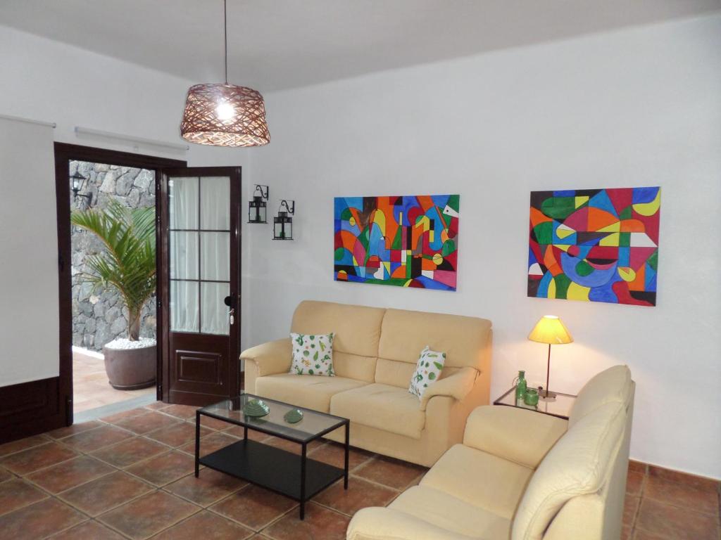 uma sala de estar com um sofá e uma mesa em Apartamento rural Los Roferos em Guatiza