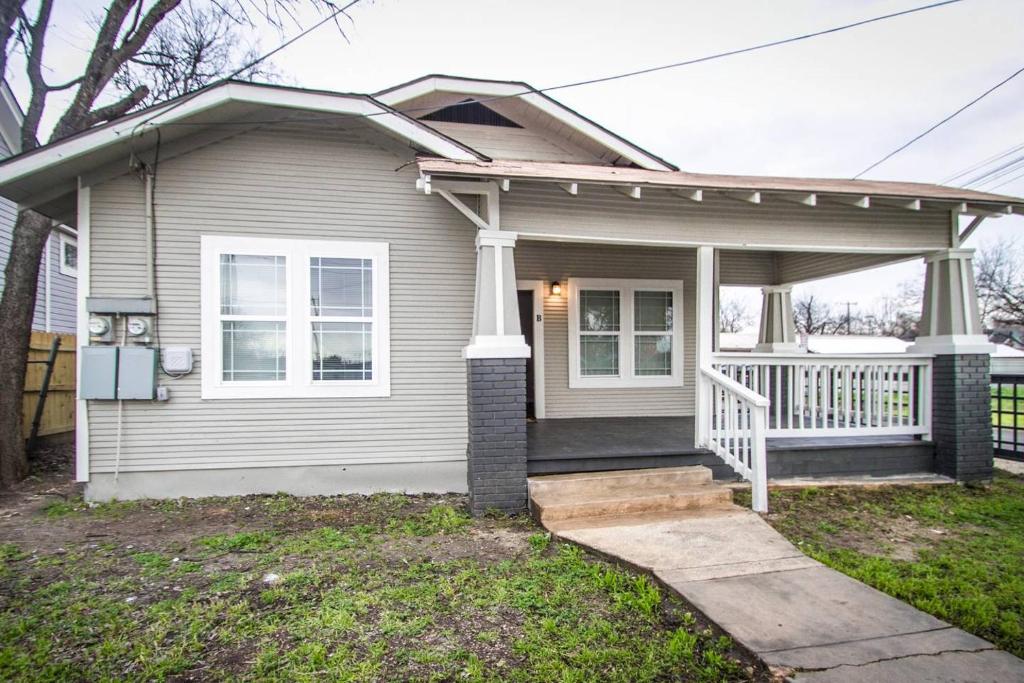 a small house with a porch and a white fence at Hackberry St #B Renovated 2BR Near Downtown SA in San Antonio