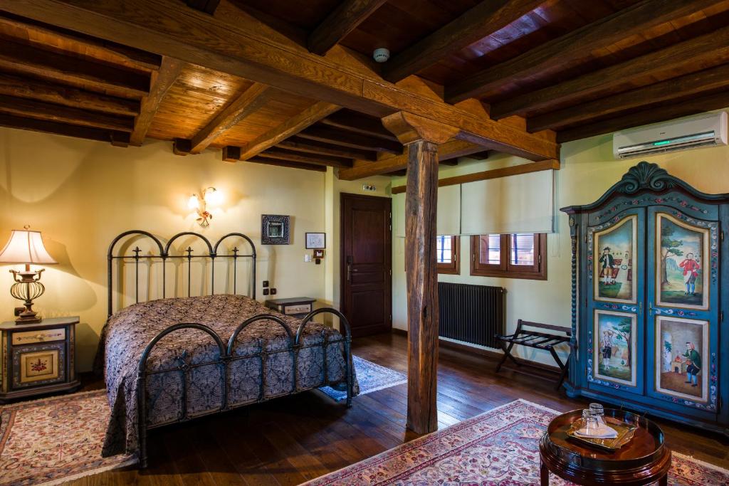 una camera con letto in una stanza con soffitti in legno di Boutique Hotel Kokkino Spiti a Veria