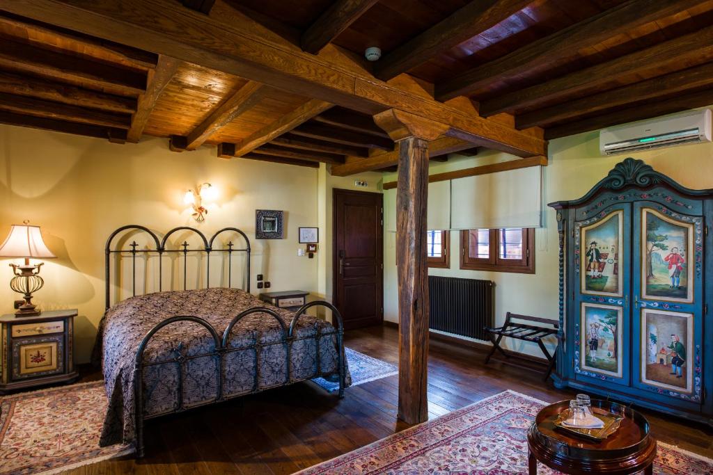 a bedroom with a bed in a room with wooden ceilings at Boutique Hotel Kokkino Spiti in Veria