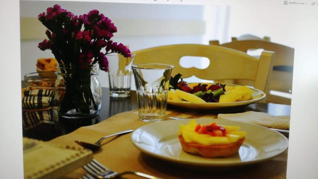 una mesa con un plato de comida y un bol de fruta en Dimora delle Rondini, en Polignano a Mare
