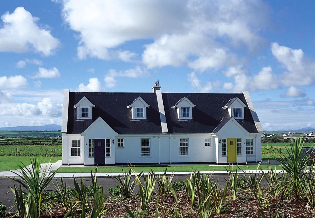 a large white house with a black roof at Ballybunion Holiday Homes No 27 in Ballybunion